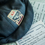 A closeup of Luther College archive documentation and a vintage flat cap