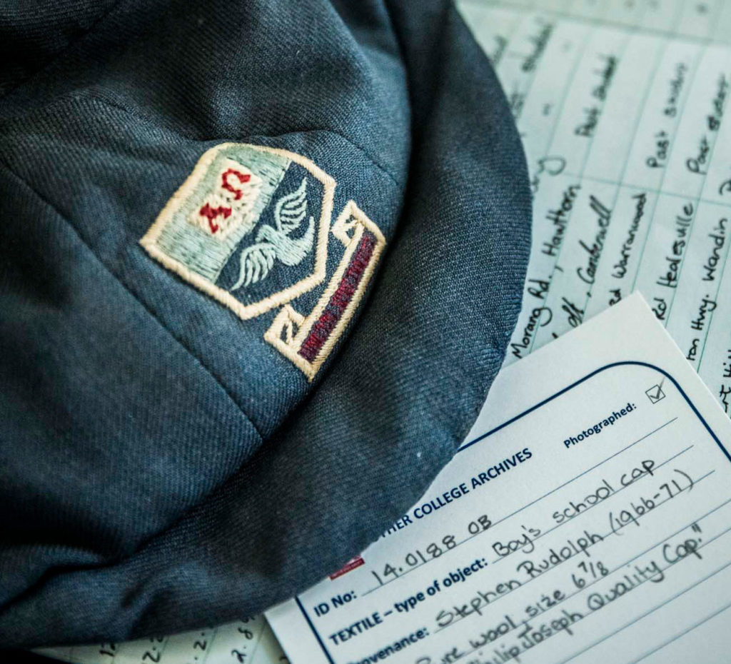 A closeup of Luther College archive documentation and a vintage flat cap