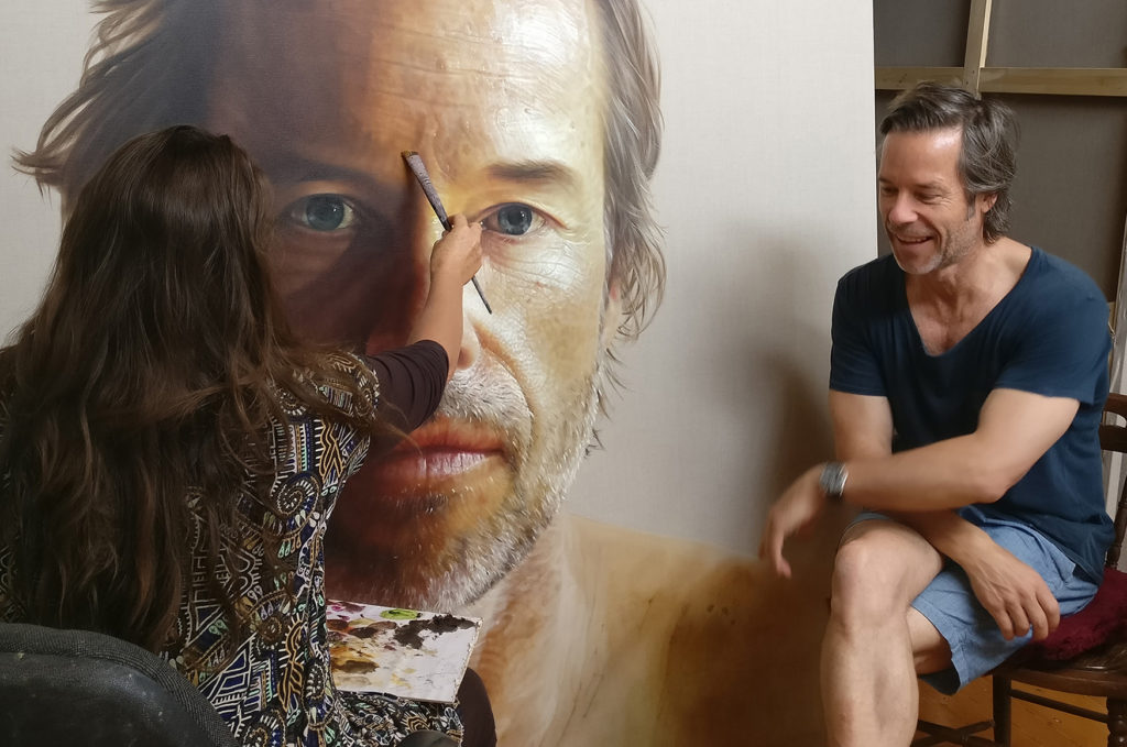 Alum Anne Middleton working on a portrait of Guy Pearce as he sits next to her