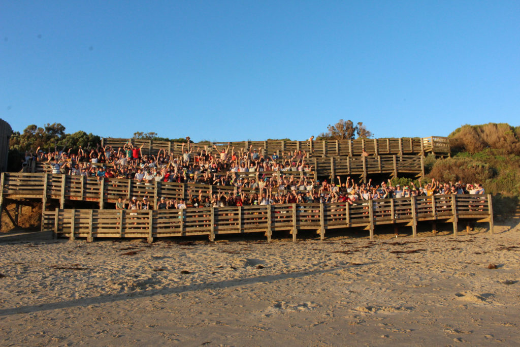 A group of students take a photo together on a beach ramp