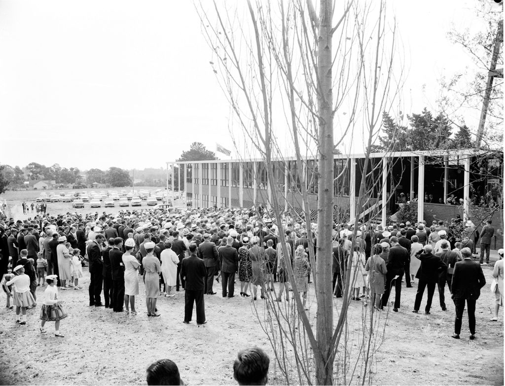 A crowd gathers in a historic black and white image of the bell tower